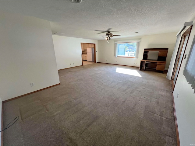 unfurnished living room with a textured ceiling, ceiling fan, and light carpet