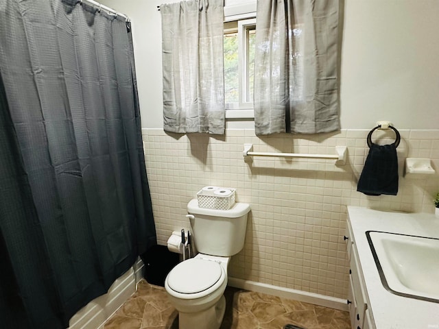 bathroom featuring toilet, tile walls, vanity, and curtained shower