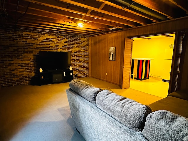 carpeted living room featuring brick wall and wooden walls