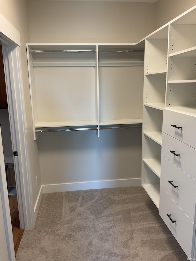 walk in closet with dark carpet