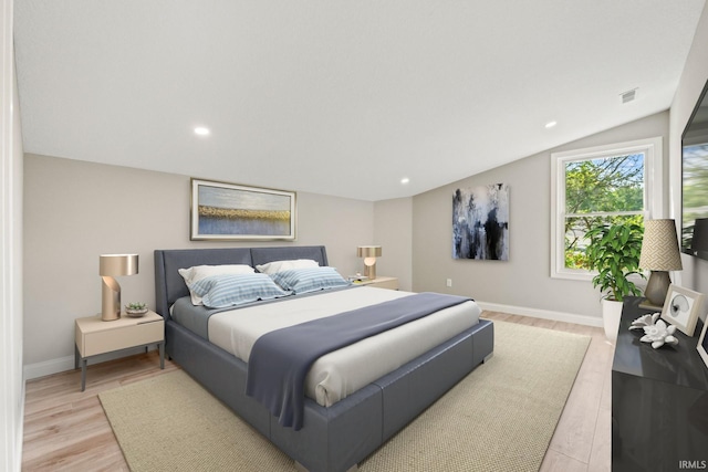 bedroom featuring light wood-type flooring and vaulted ceiling