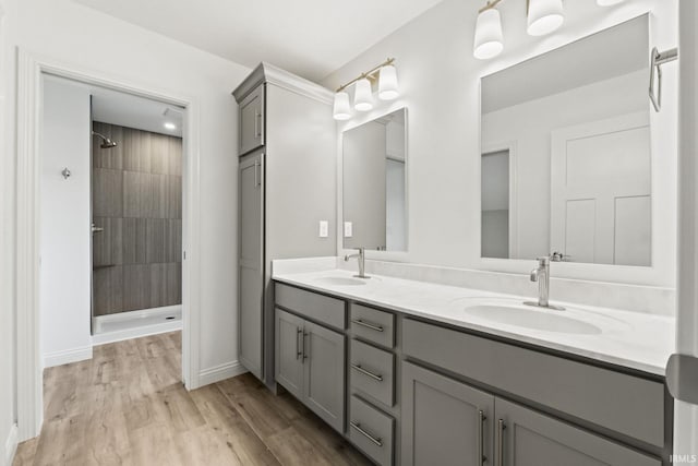 bathroom with a tile shower, hardwood / wood-style floors, and vanity