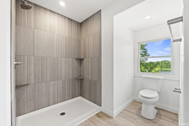 bathroom featuring a shower, toilet, and wood-type flooring