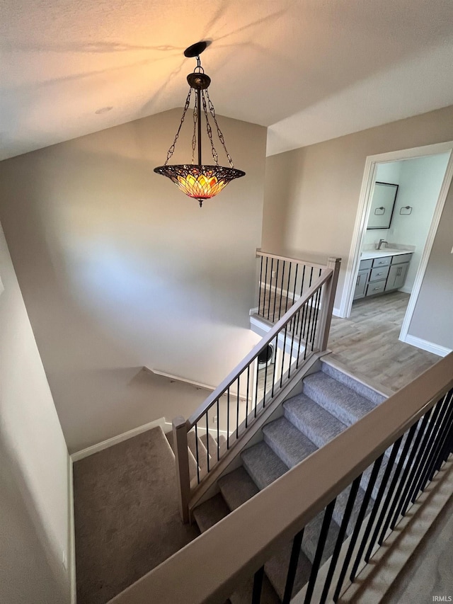 staircase featuring wood-type flooring and sink