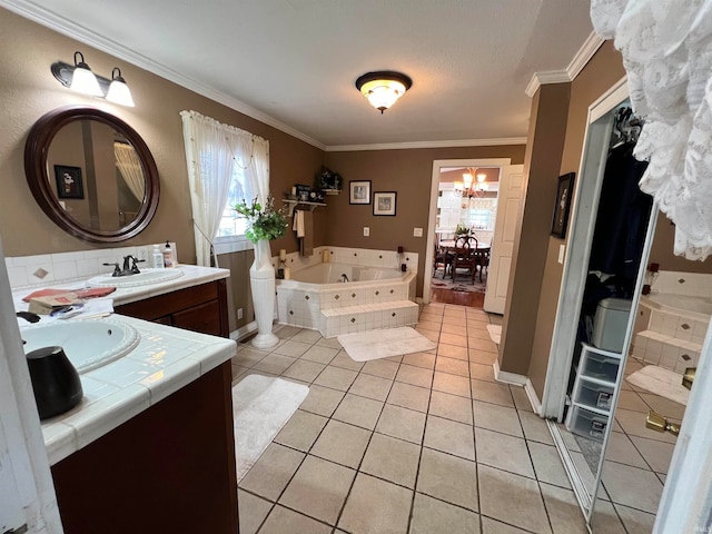 bathroom featuring vanity, tile patterned flooring, a relaxing tiled tub, ornamental molding, and a notable chandelier