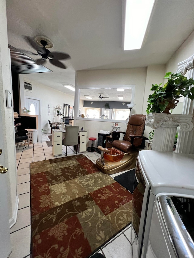 interior space with ceiling fan, light tile patterned flooring, and washing machine and dryer