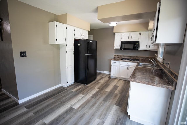 kitchen with white cabinets, black appliances, dark hardwood / wood-style floors, and sink