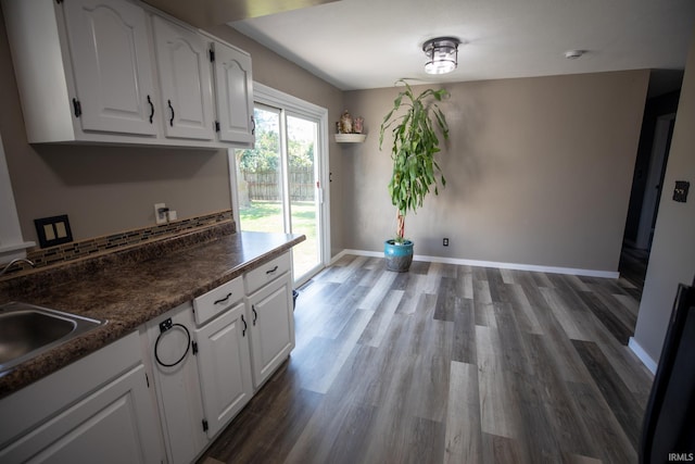 kitchen with white cabinets, hardwood / wood-style floors, and sink