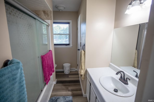 bathroom with bath / shower combo with glass door, vanity, and hardwood / wood-style flooring