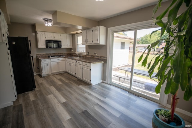 kitchen featuring black appliances, dark hardwood / wood-style flooring, sink, and white cabinets