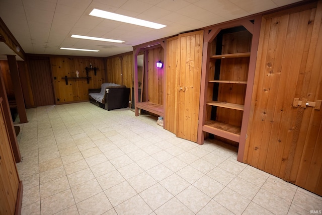 basement featuring wooden walls