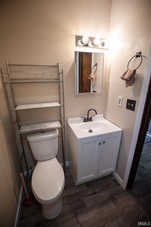 bathroom featuring vanity, hardwood / wood-style floors, and toilet