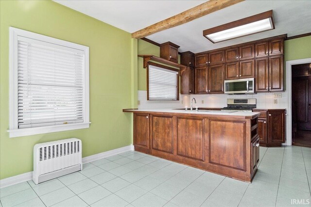 kitchen with appliances with stainless steel finishes, backsplash, and kitchen peninsula