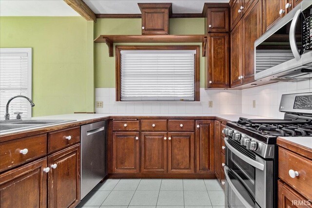 kitchen with appliances with stainless steel finishes, backsplash, and light tile patterned flooring