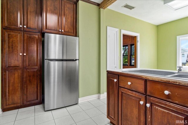 kitchen with stainless steel refrigerator and light tile patterned flooring