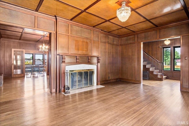 unfurnished living room with a high end fireplace, a chandelier, hardwood / wood-style flooring, and wooden ceiling