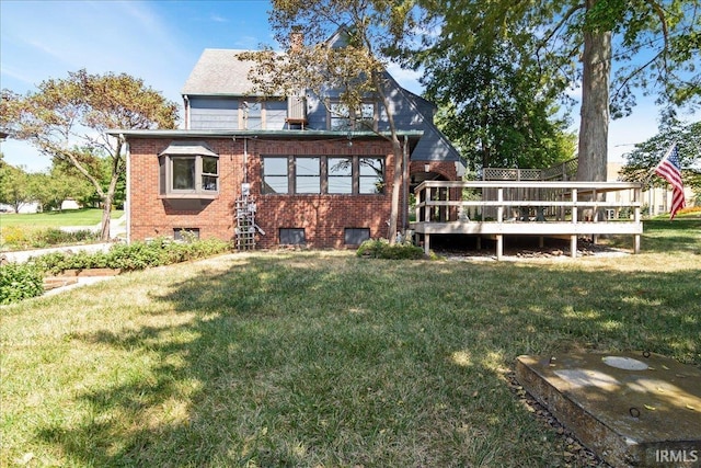 rear view of house featuring a deck and a yard