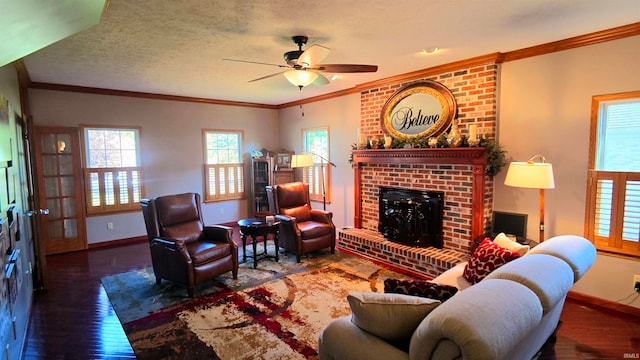 living room featuring dark hardwood / wood-style flooring, a textured ceiling, a fireplace, crown molding, and ceiling fan