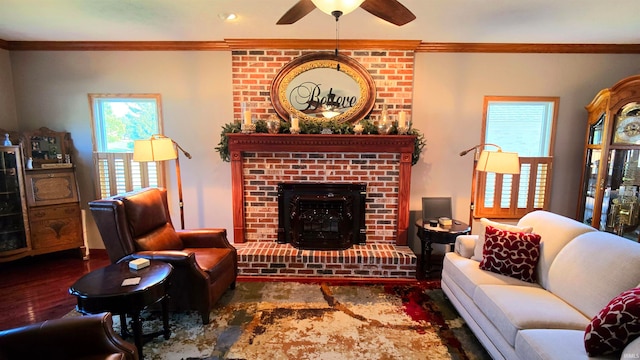 living room with ceiling fan, ornamental molding, a fireplace, and dark hardwood / wood-style flooring