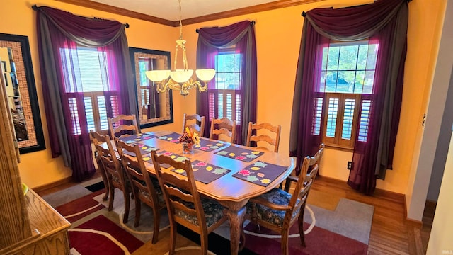 dining area with an inviting chandelier, wood-type flooring, and ornamental molding