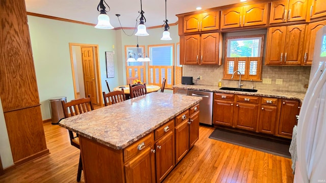 kitchen featuring pendant lighting, light wood-type flooring, sink, a kitchen island, and stainless steel dishwasher