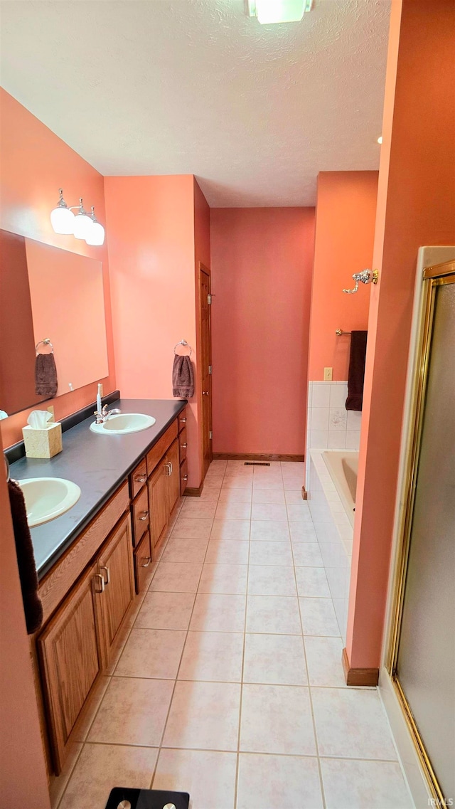 bathroom featuring independent shower and bath, vanity, tile patterned flooring, and a textured ceiling