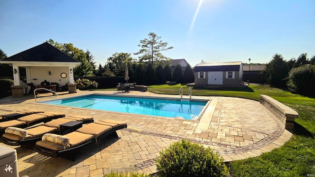 view of pool featuring a patio, an outbuilding, and a yard