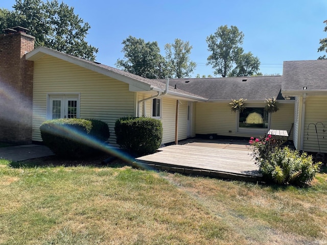 back of house with a deck and a yard