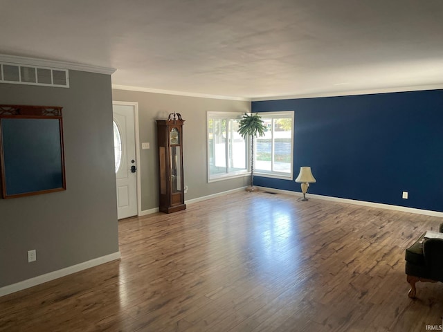 unfurnished living room with wood-type flooring and ornamental molding