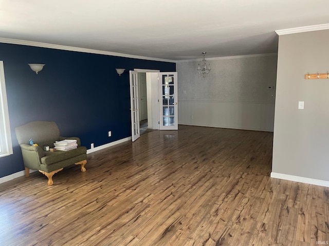 empty room with crown molding, hardwood / wood-style floors, and a chandelier