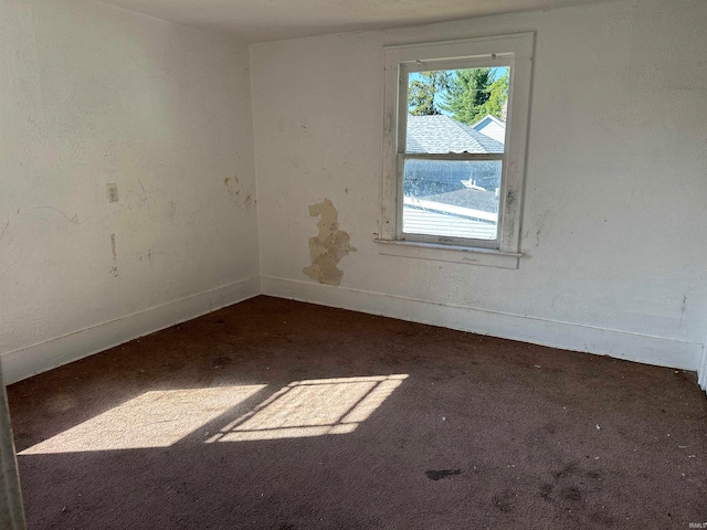 empty room with dark carpet and plenty of natural light