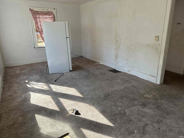 interior space with carpet and white fridge