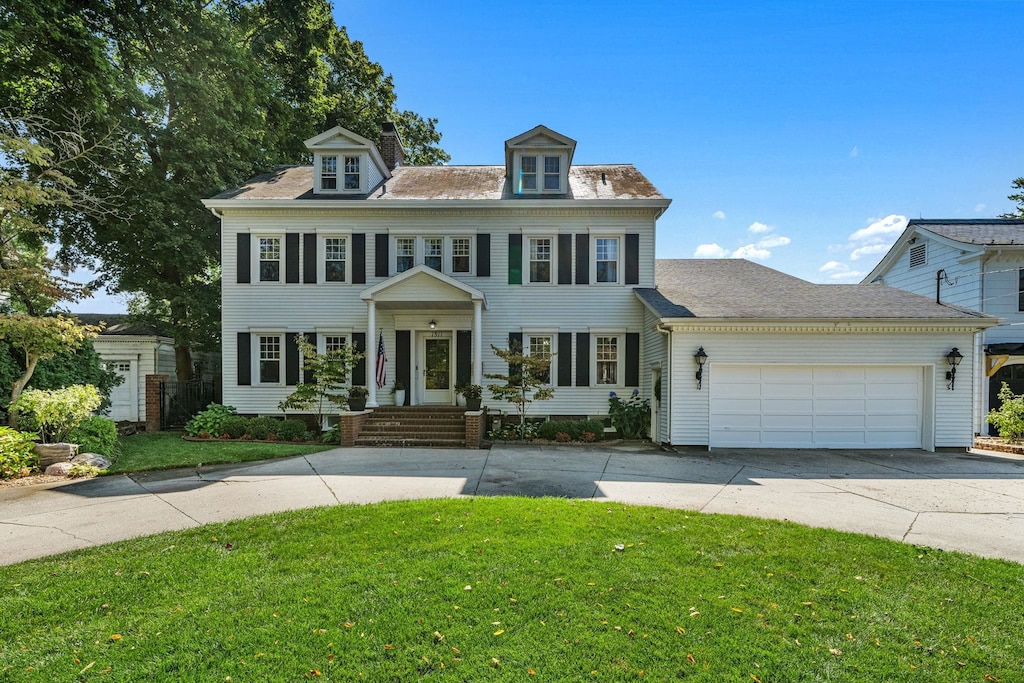 colonial home with a garage and a front yard