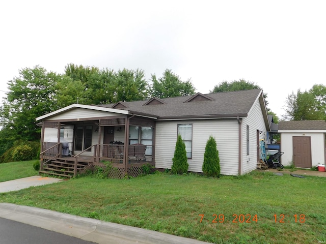 view of front of home featuring a front yard and a storage unit