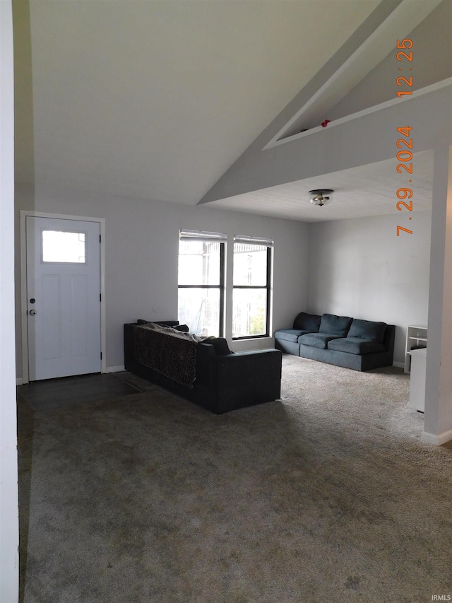 living room featuring lofted ceiling, dark carpet, and a wealth of natural light