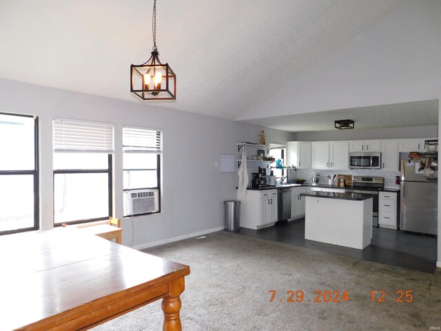 kitchen with white cabinets, vaulted ceiling, an inviting chandelier, stainless steel appliances, and decorative light fixtures