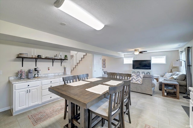 dining area featuring ceiling fan and a textured ceiling