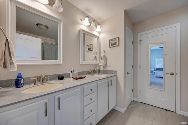 bathroom featuring a textured ceiling, tile patterned flooring, and vanity