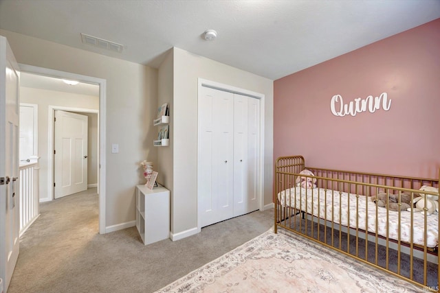 bedroom with light carpet, a closet, and a crib