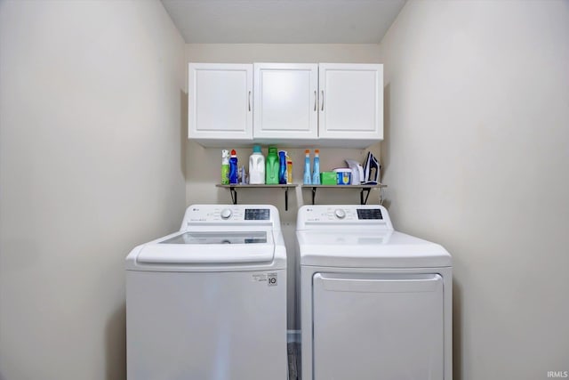 clothes washing area featuring cabinets and washer and dryer