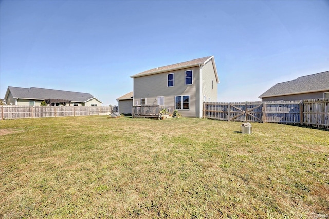 rear view of property with a yard and a wooden deck