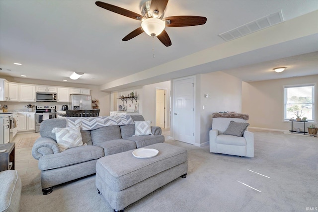 carpeted living room featuring ceiling fan