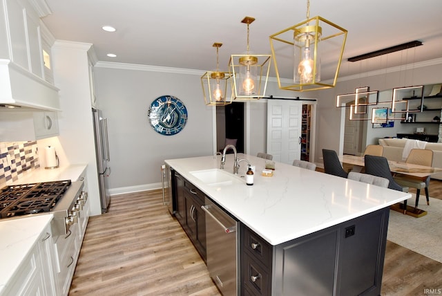 kitchen featuring a sink, stainless steel appliances, light wood-style flooring, and crown molding