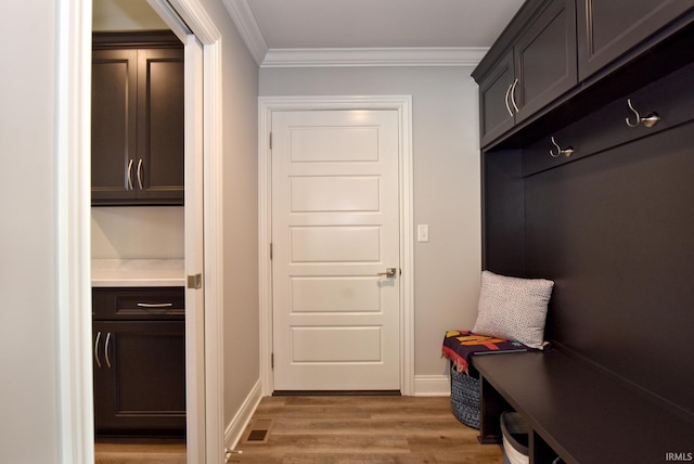 mudroom featuring crown molding, light wood-style flooring, baseboards, and visible vents
