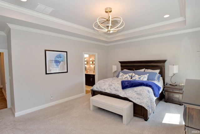 carpeted bedroom featuring ornamental molding, a notable chandelier, a tray ceiling, and ensuite bathroom