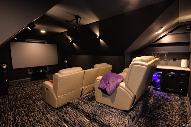 carpeted home theater room with a bar and lofted ceiling