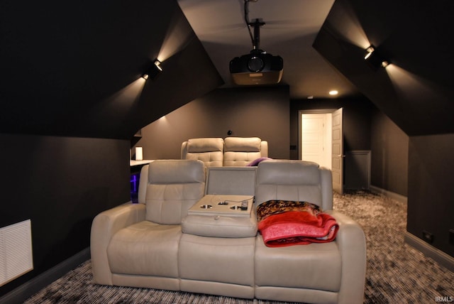 carpeted cinema featuring visible vents, track lighting, lofted ceiling, and baseboards