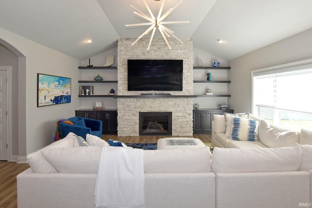 living room with a chandelier, vaulted ceiling, a stone fireplace, dark hardwood / wood-style flooring, and built in features