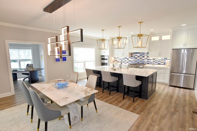 dining space featuring crown molding and light hardwood / wood-style floors