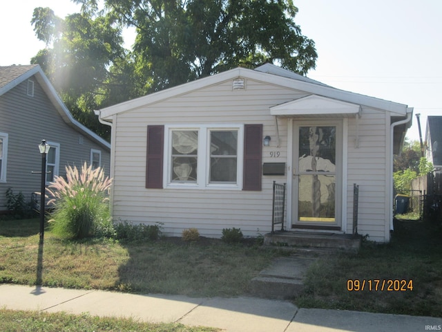 bungalow-style house featuring a front yard